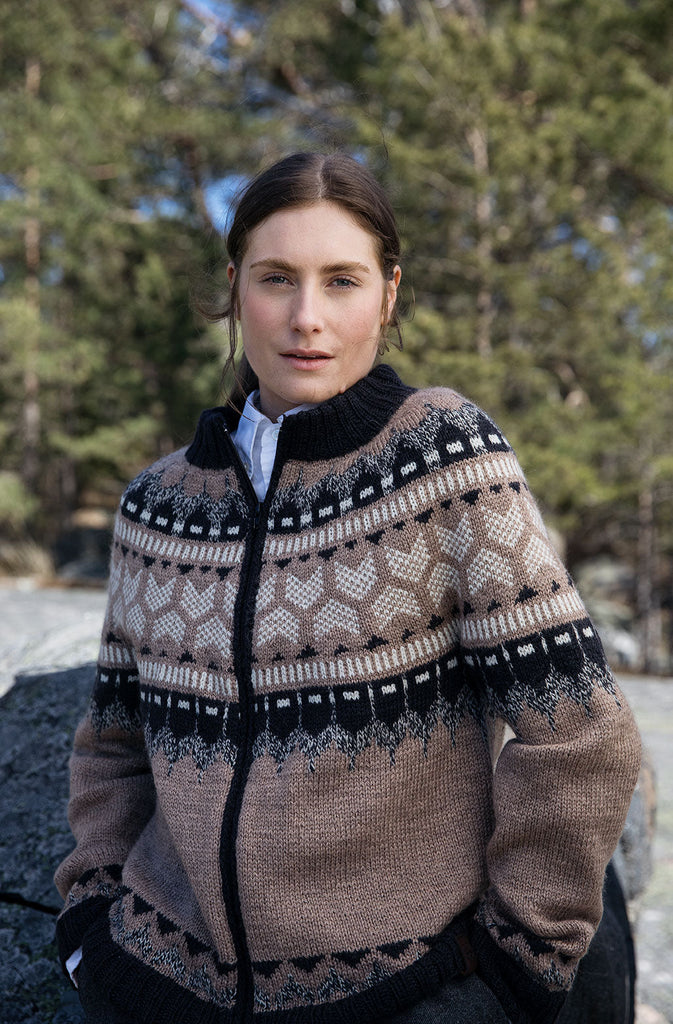 Woman wearing a patterned sweater outdoors with trees in the background