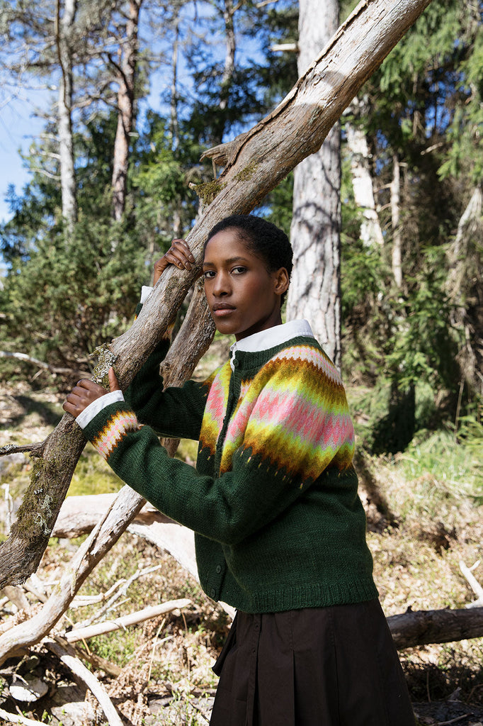 Person wearing a colorful sweater in a forest setting