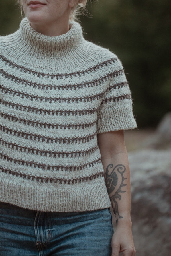 Person wearing a knitted sweater with a blurred background