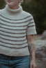 Person wearing a knitted sweater with a blurred background