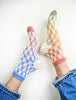 Colorful checkered socks worn by a person on a white background