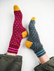 Colorful patterned socks with yellow toes and blue accents on a white background