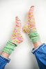 Colorful knitted socks worn with blue jeans on a white background