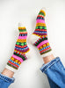 Colorful patterned socks worn with blue jeans on a white background