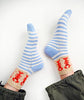 Blue and white striped socks with red patterns on a white background