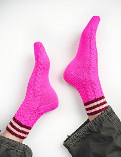 Bright pink socks with brown stripes worn by a person on a white background