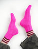 Bright pink socks with brown stripes worn by a person on a white background