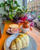 Café setting with a cup of coffee, a pastry, and decorative elements on a wooden table.