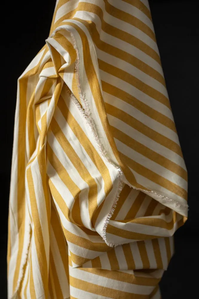 Yellow and white striped fabric against a black background