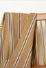 Striped fabric draped over a wooden chair with a neutral background