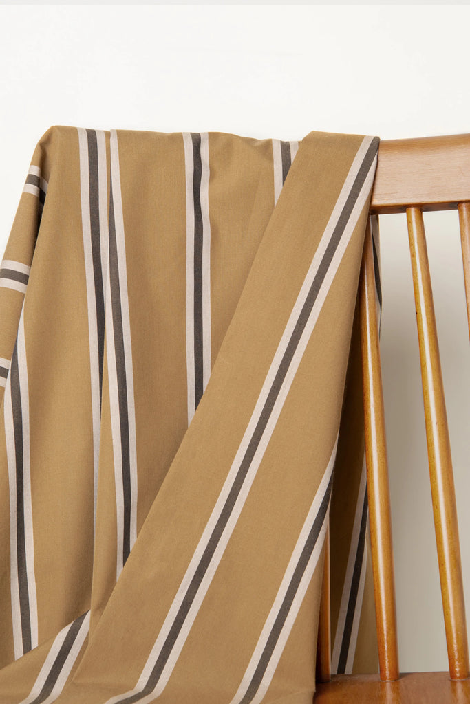 Striped fabric draped over a wooden chair with a neutral background