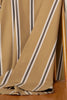 Close-up of striped fabric with brown, beige, and white colors on a wooden surface.