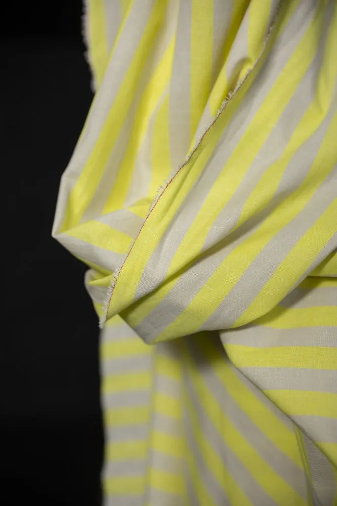 Close-up of a yellow and white striped fabric with a dark background