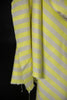 Close-up of yellow and white striped fabric with frayed edges on a black background