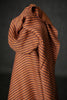 Brown striped fabric draped over a black background