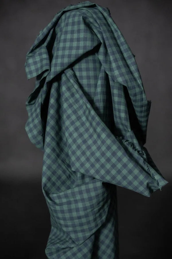 Green checkered fabric draped over a dark background