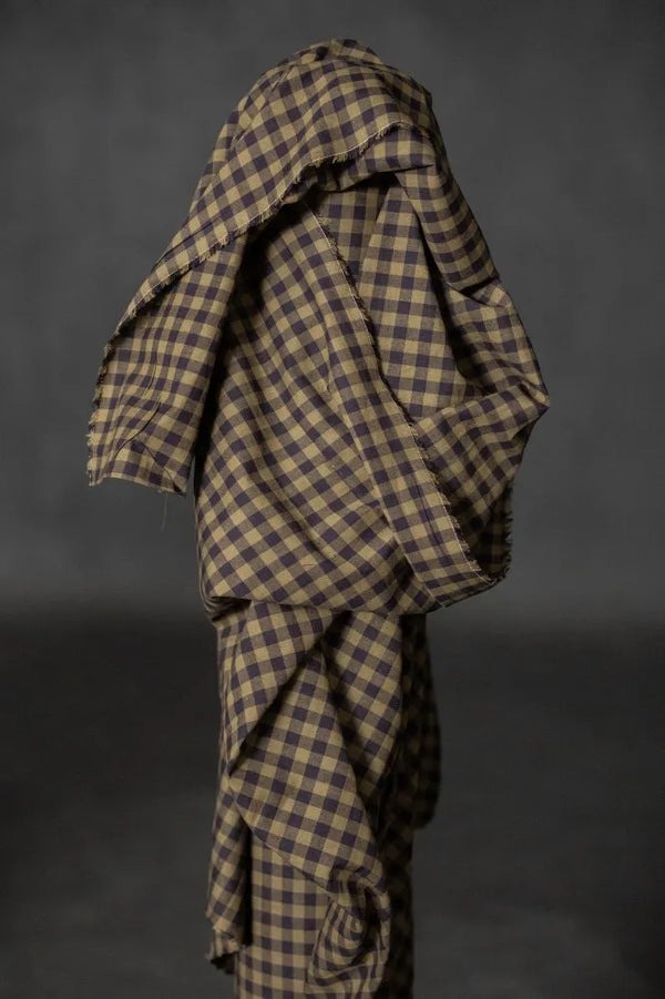 Plaid fabric draped over a dark background