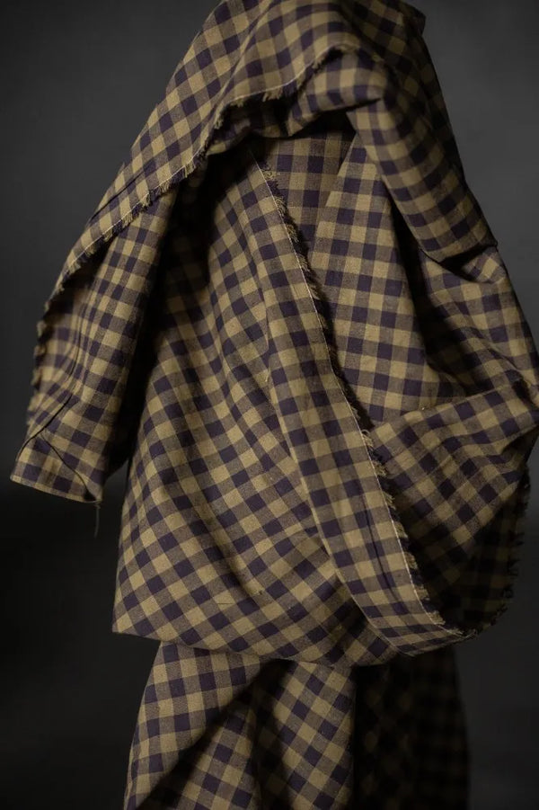 Plaid fabric with brown and blue pattern on a dark background