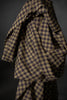 Plaid fabric with brown and blue pattern on a dark background