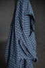 Blue checkered fabric draped over a surface with a dark background