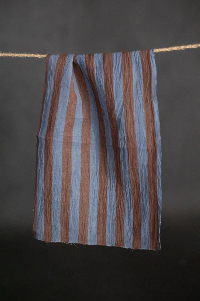 Striped fabric hanging on a line against a dark background