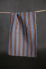 Striped fabric hanging on a line against a dark background