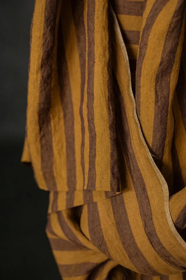 Close-up of a yellow and brown striped fabric with a dark background