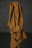 Brown striped fabric draped over a dark background