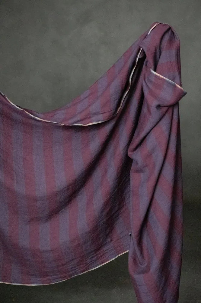 Striped fabric draped over a surface with a neutral background