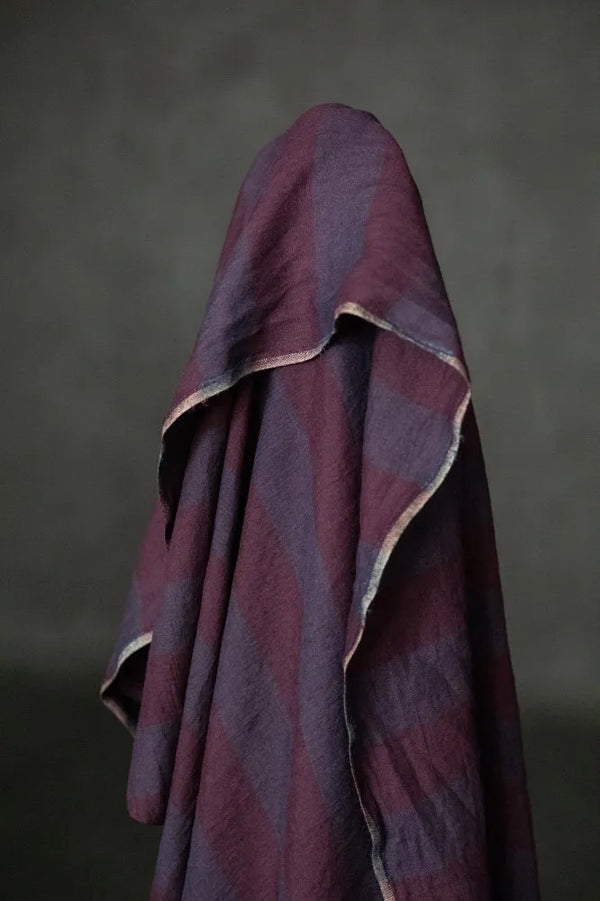 Purple textured fabric draped over a neutral background