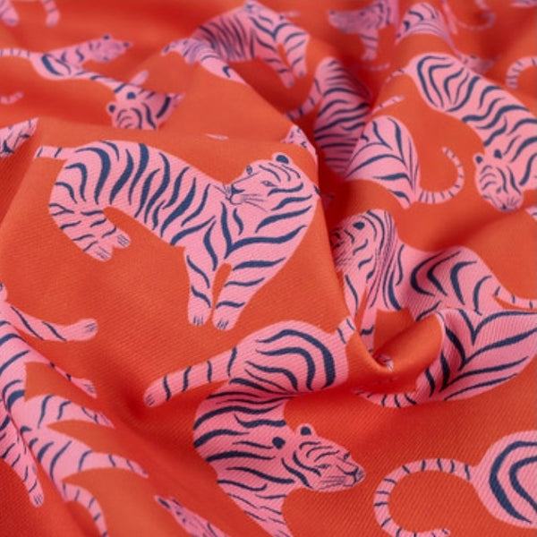 Fabric with pink and black tiger pattern on an orange background