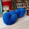 one blue yarn skein on a surface with a blurred background
