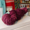 skein of burgundy purple wool on wooden shelf