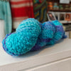 Blue and purple knitted yarn on a white surface with a blurred background
