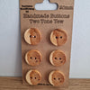 6 wooden buttons on a piece of brown card