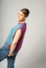 Person wearing a two-tone sleeveless sweater with blue and purple colors on a plain background