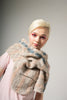 Woman wearing a textured beige scarf against a plain background