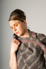 Woman wearing a textured scarf against a plain background