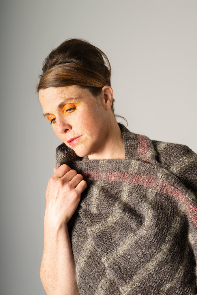 Woman wearing a textured scarf against a plain background