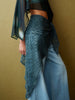 Person wearing a textured blue garment over a plain background