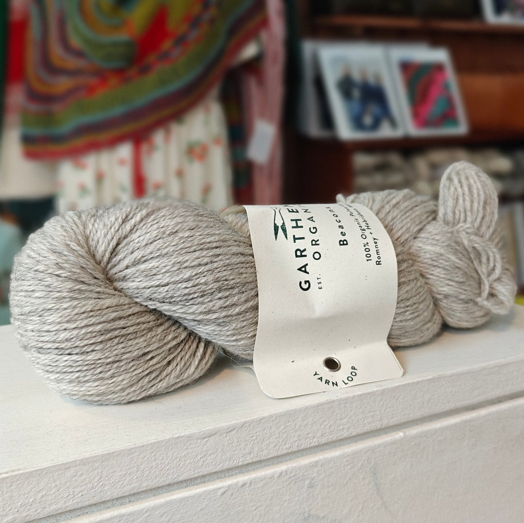 a skein of light grey yarn on a shelf in a shop