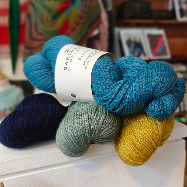 4 skeins of wool on a shelf in a shop